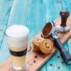 Coffee with Cream Foam on Top and Cinnamon Rolls and Coffee Tools - Frappe