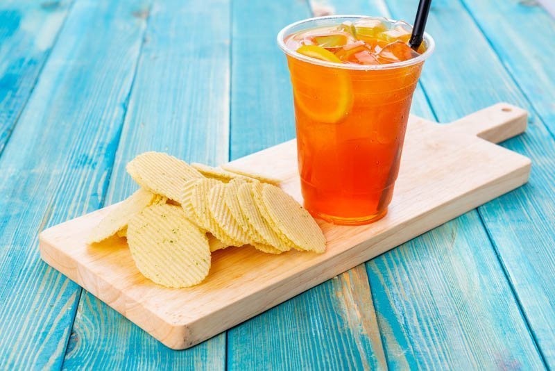 Orange Juice with Chips - Potato Chips with Orange Juice on Blue Wood Backgro